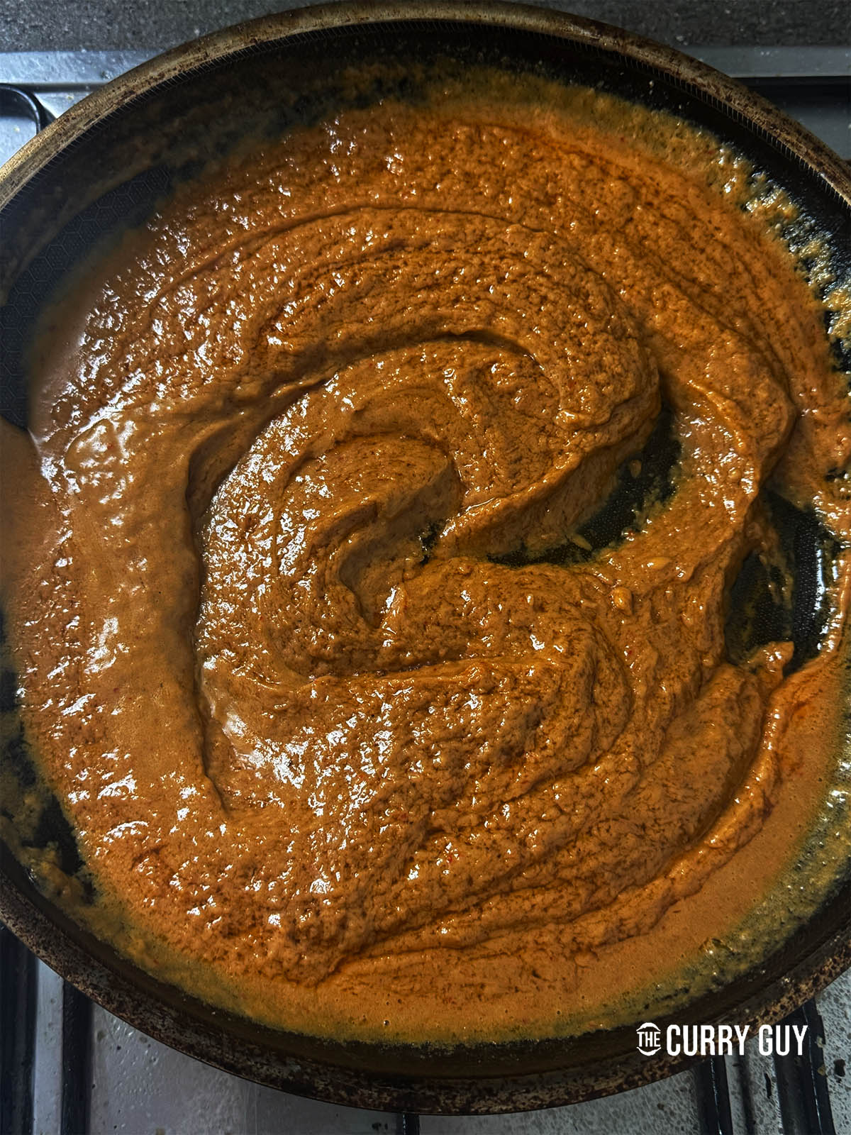 Stirring the peanut sauce over the heat to thicken some.