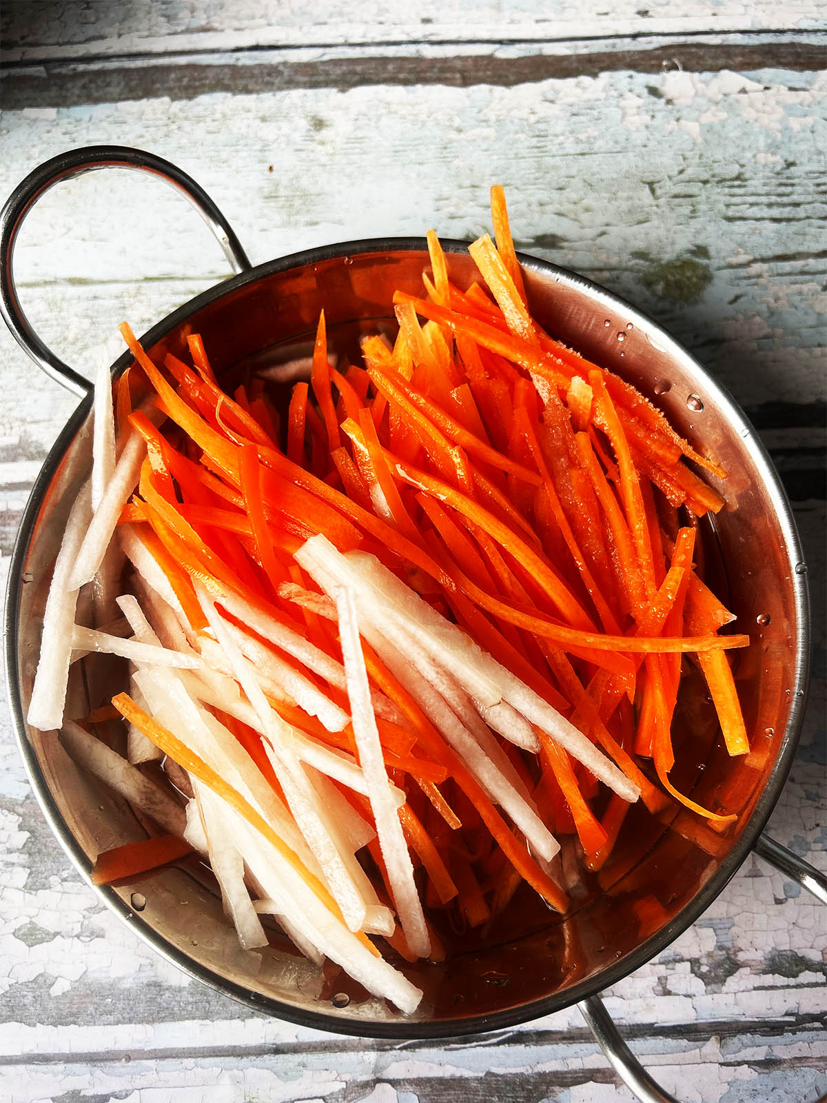 Daikon added to the carrots in the bowl.