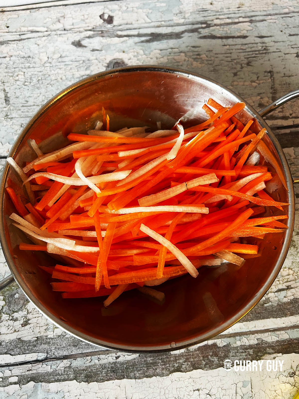 The carrots and daikon mixed together in a bowl.