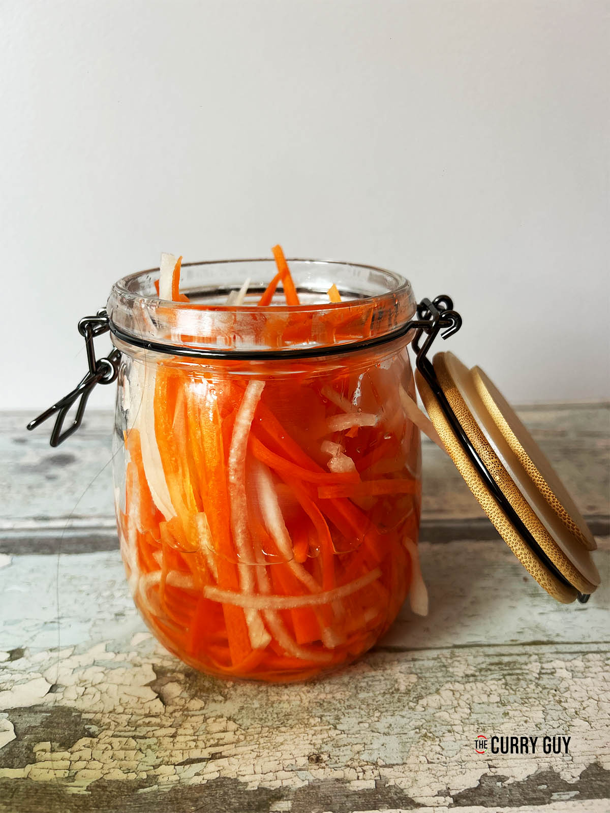 Adding the carrots and daikon to the jar