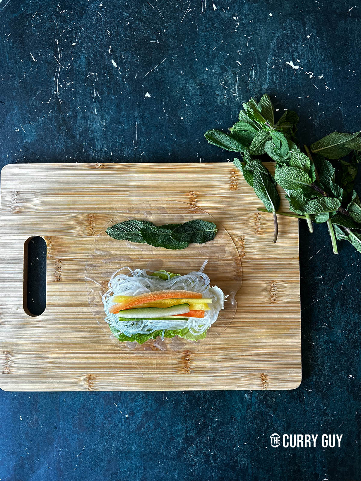 Adding fresh mint leaves to the other side of the rice paper.