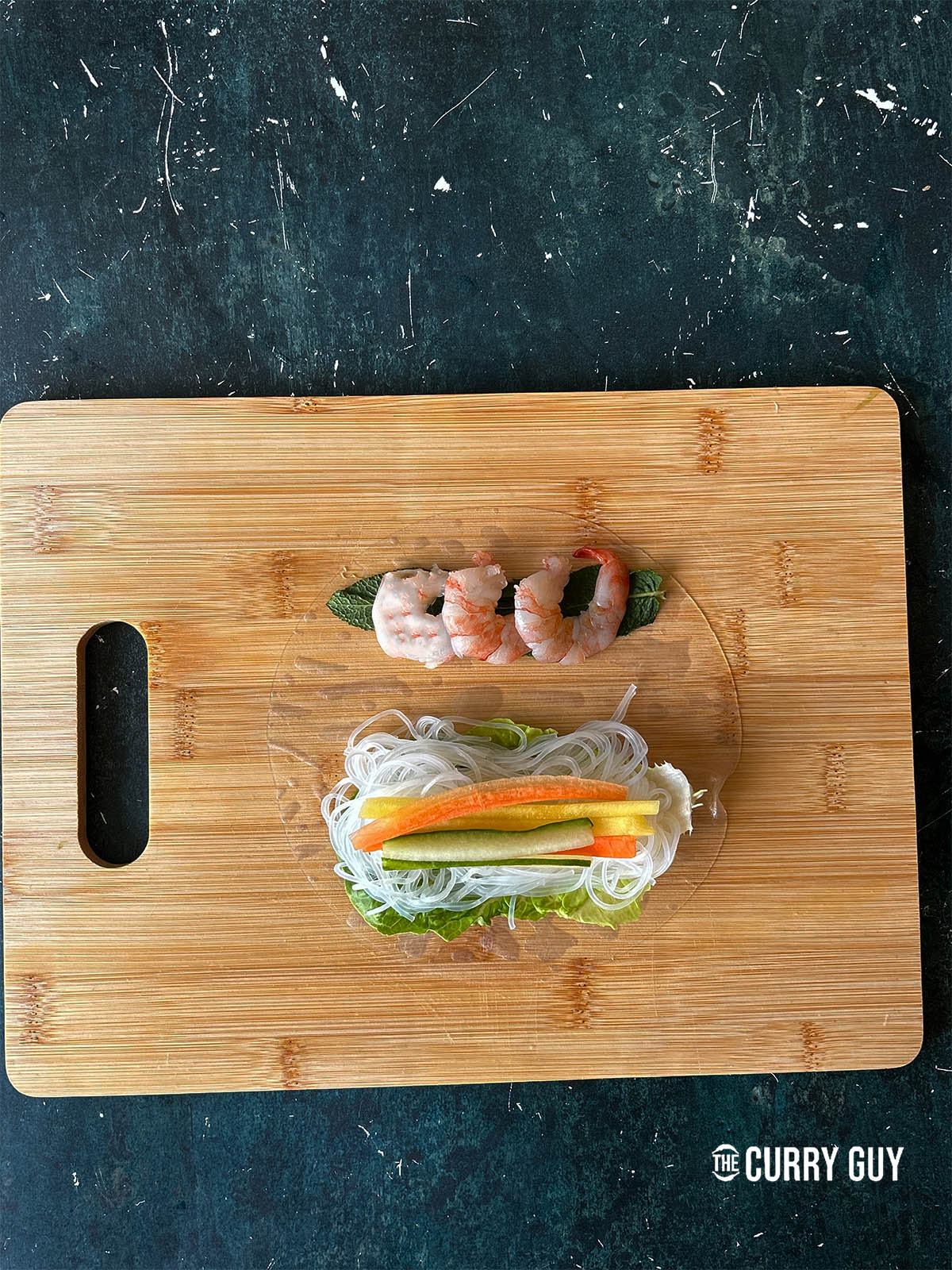 Topping the fresh mint with cooked prawns (shrimp)