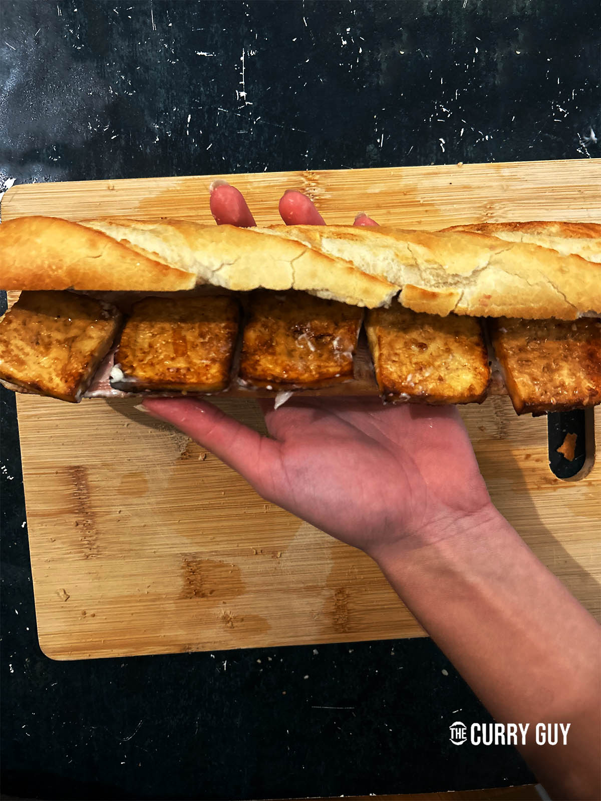 Adding the hot tofu on top of the mayonnaise and pate.