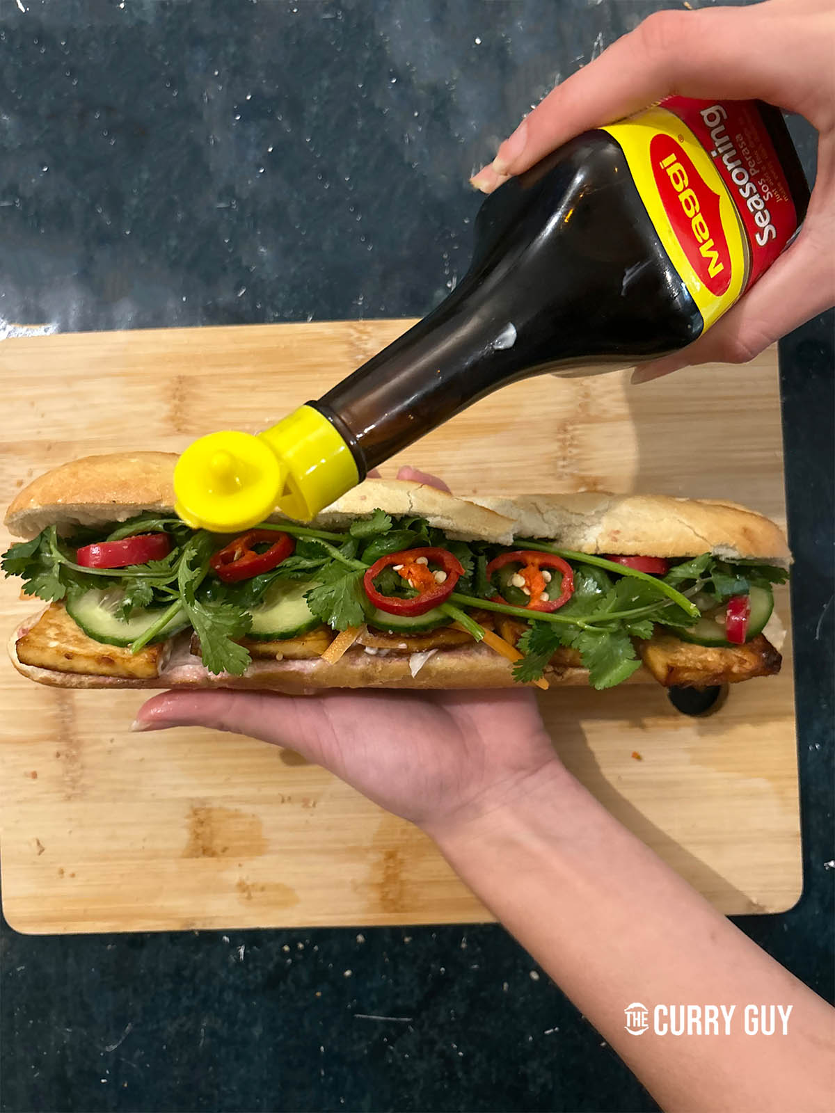 Adding magi seasoning to the tofu banh mi.