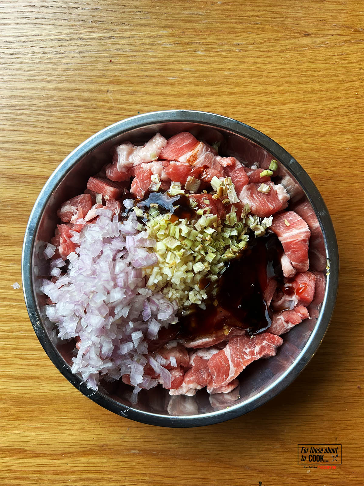 The marinade ingredients in a bowl with the pork.