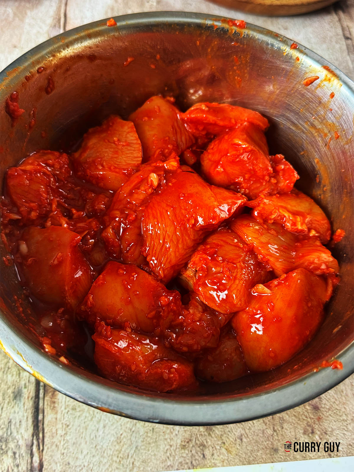 Mixing the first marinade into the chicken.