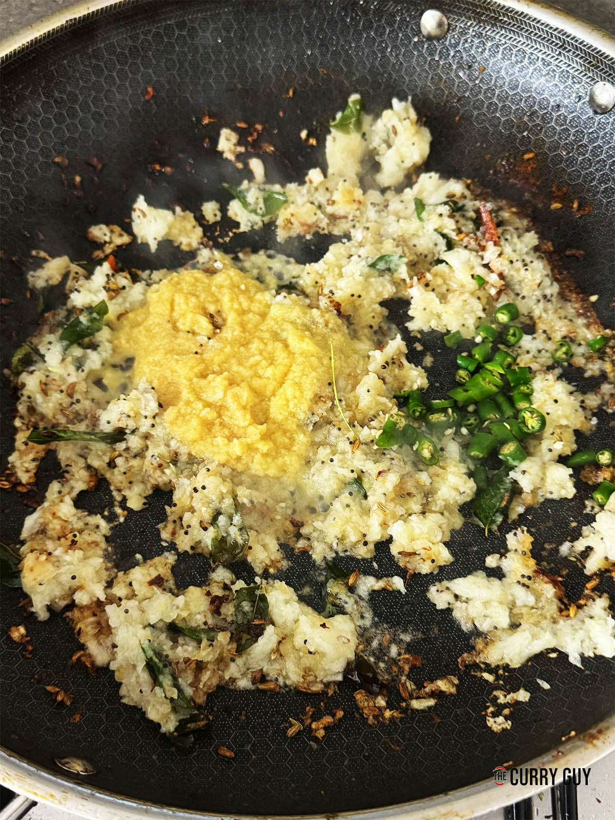 Adding the garlic and ginger paste and chopped chillies to the pan.