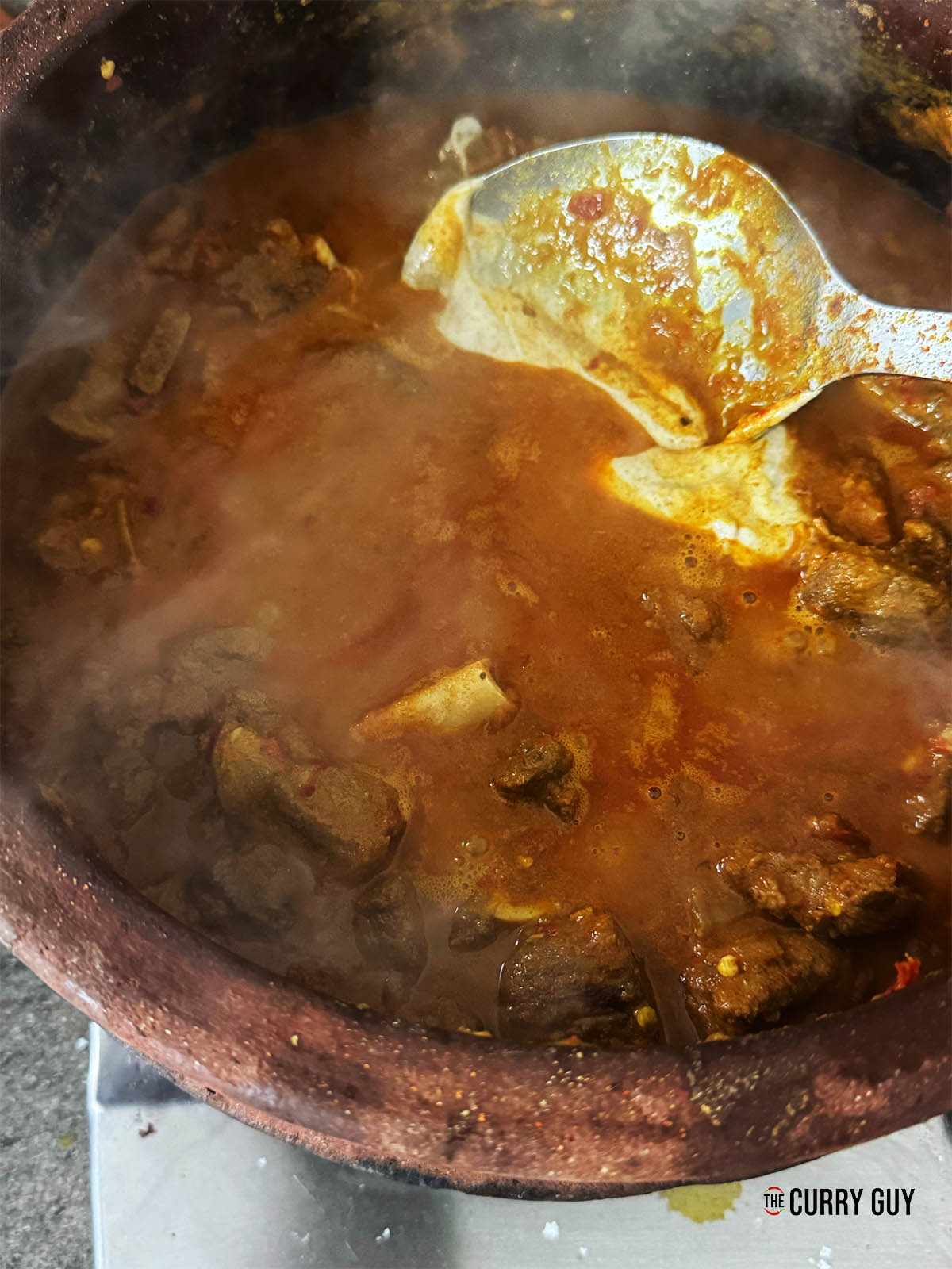 Adding the spiced yoghurt to the curry.