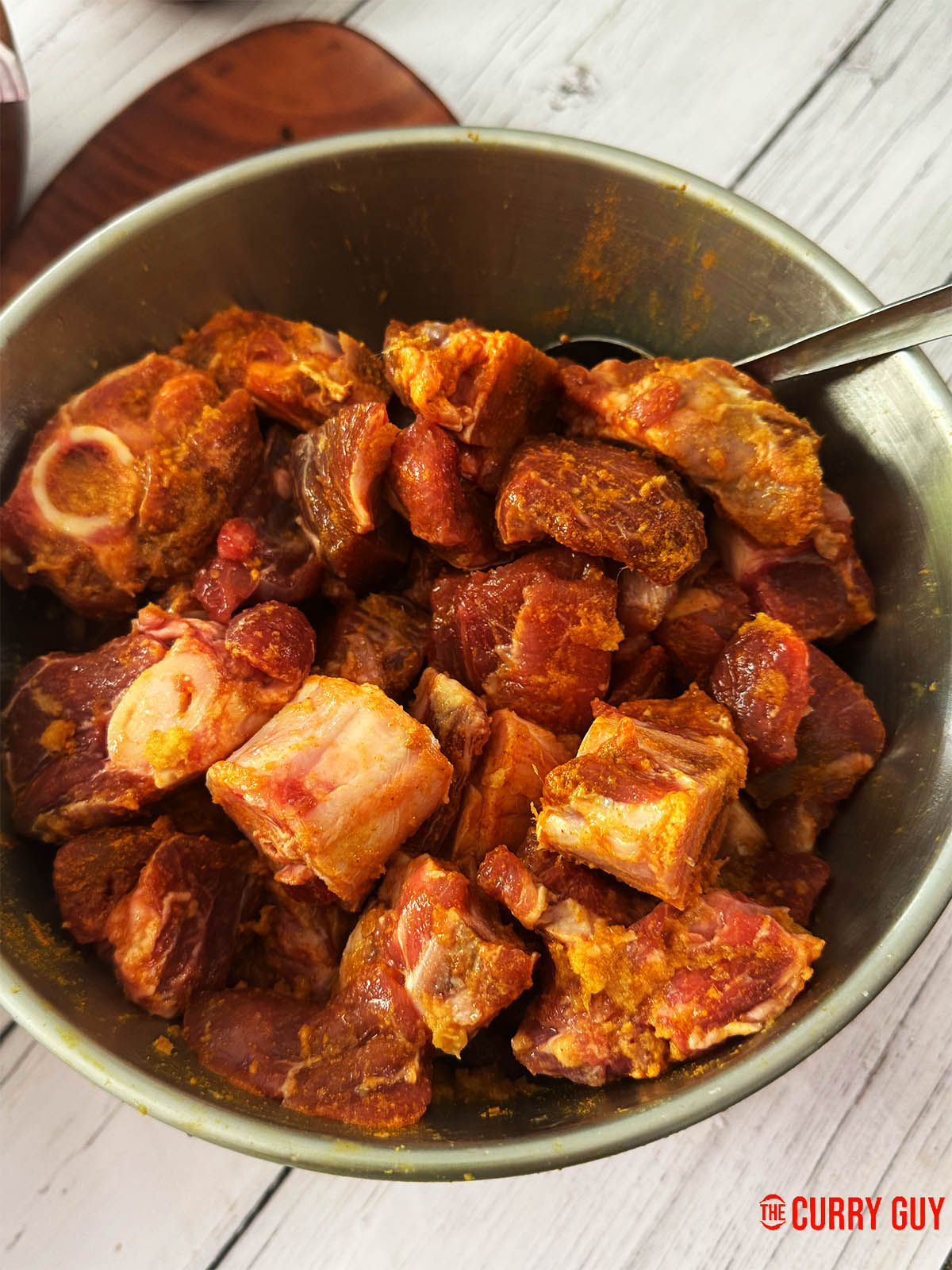Marinating the meat in garlic and ginger paste, salt and turmeric.