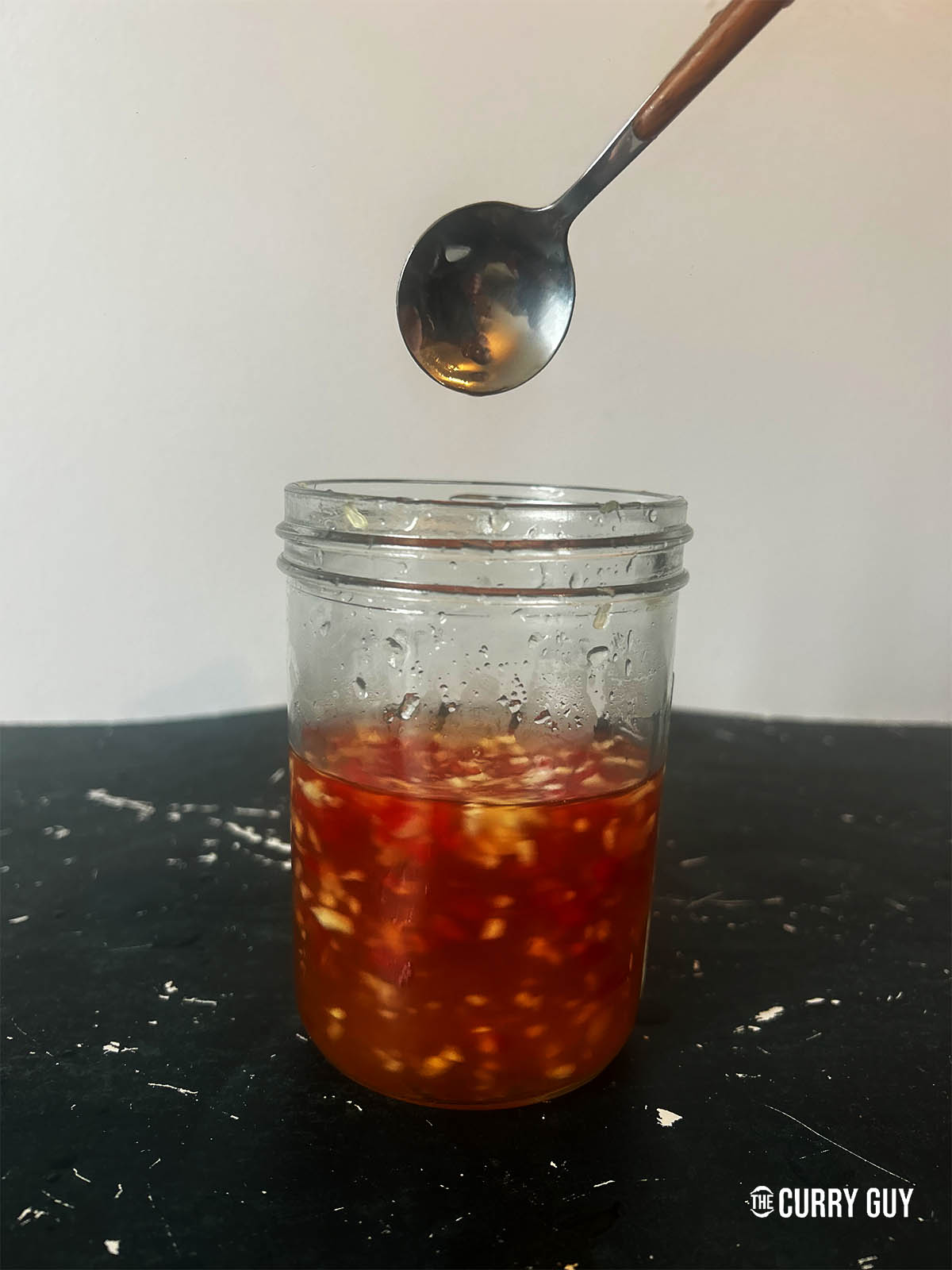 Nuoc cham in a jar after stirring together with a spoon.