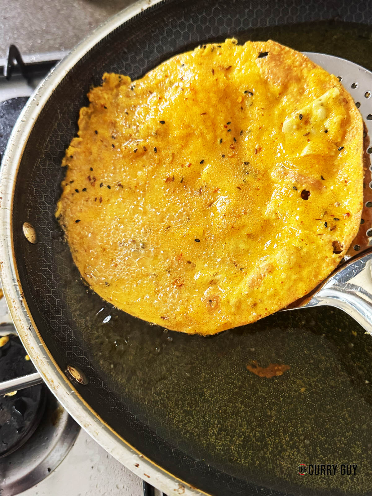 Removing the papada vada from the hot oil when cooked.