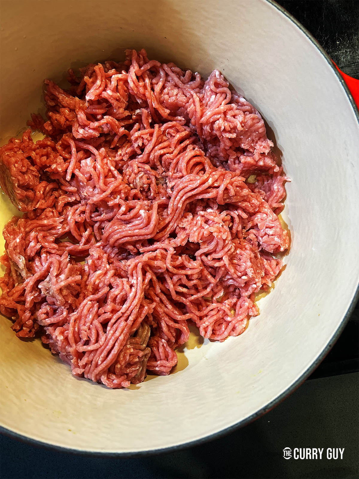 Adding the meat to the hot sesame oil in the pan.