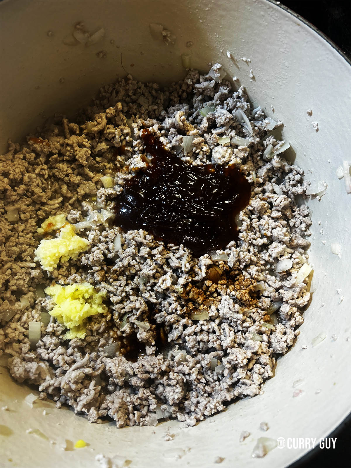 Adding the soy sauce, vinegar, garlic, ginger and gochujang to the pan.