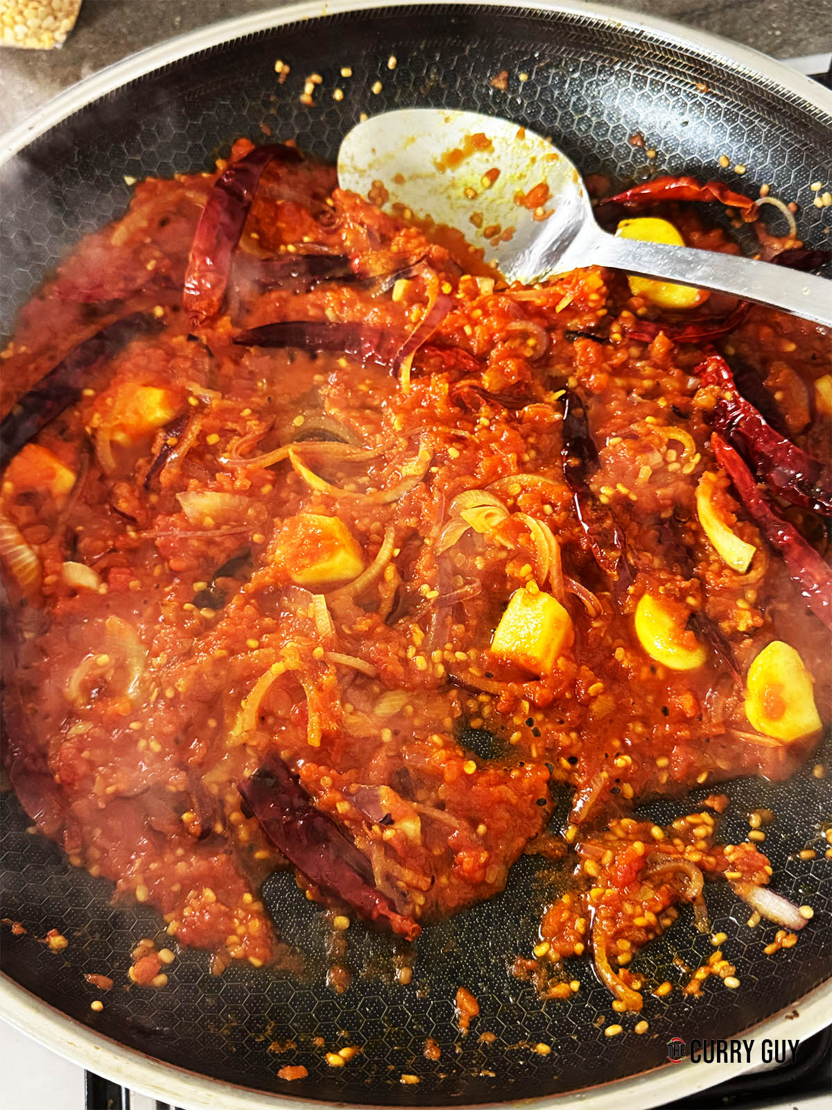 Adding the chopped tomatoes to the pan.