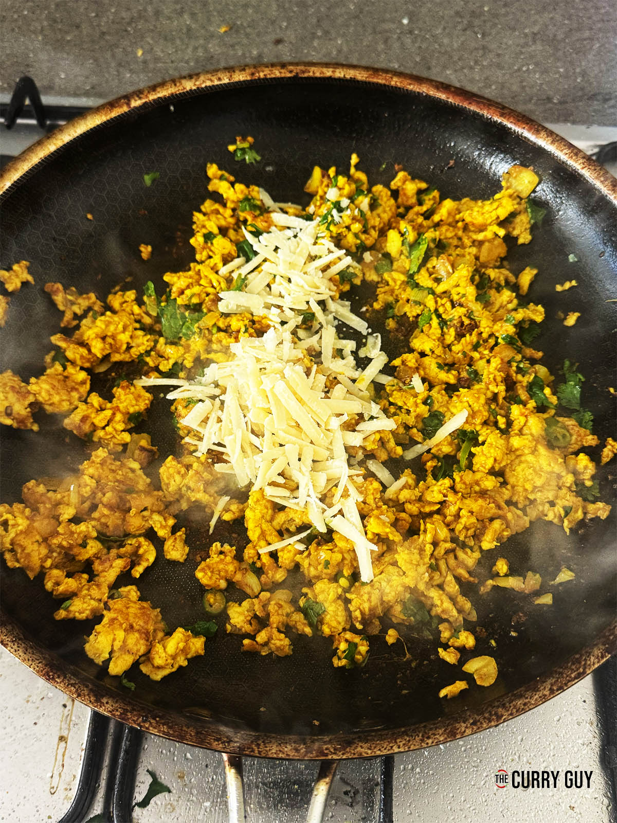Stirring in the Parmesan, coriander and vinegar.