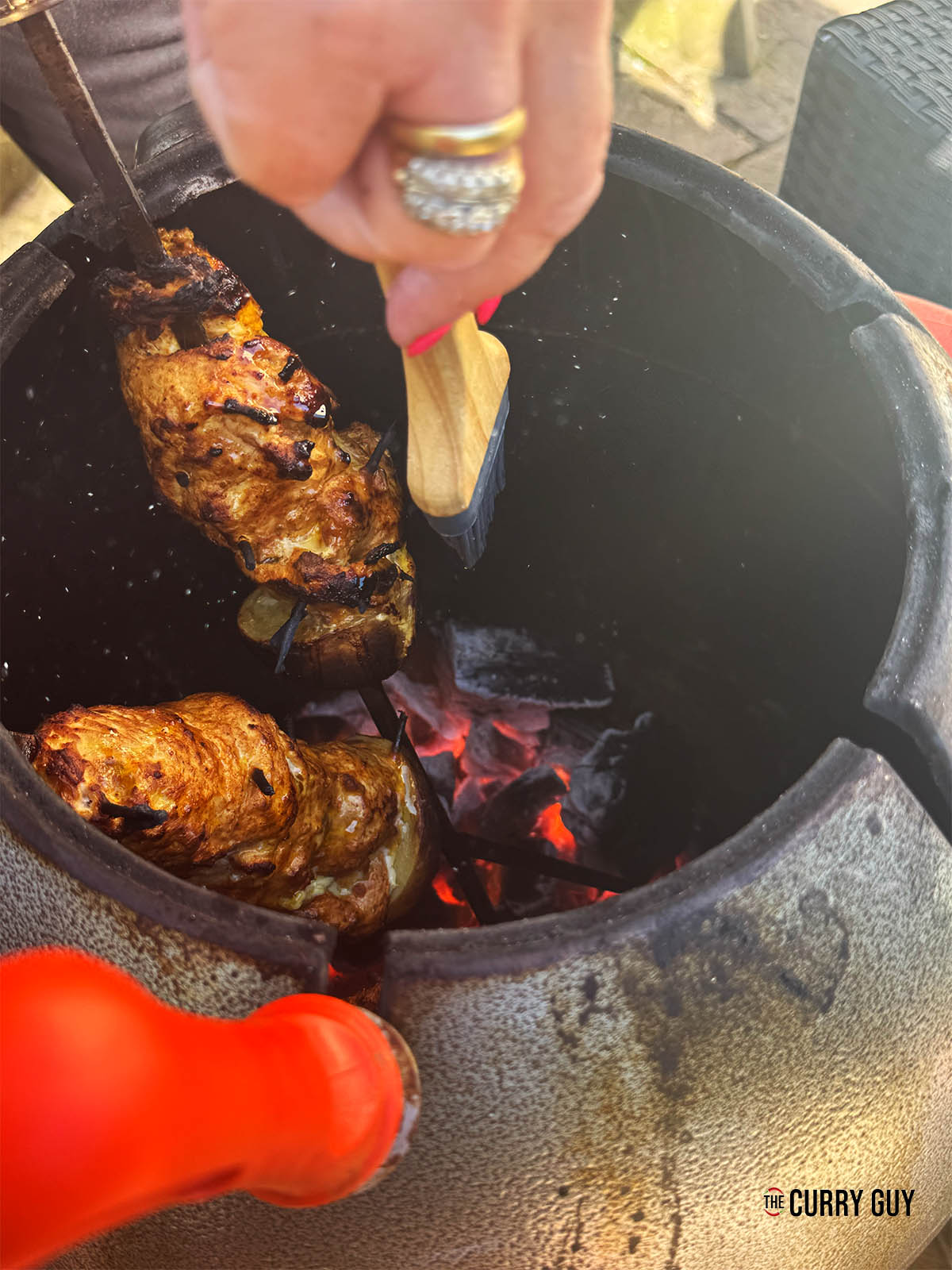 Cooking the chicken in a tandoor oven.