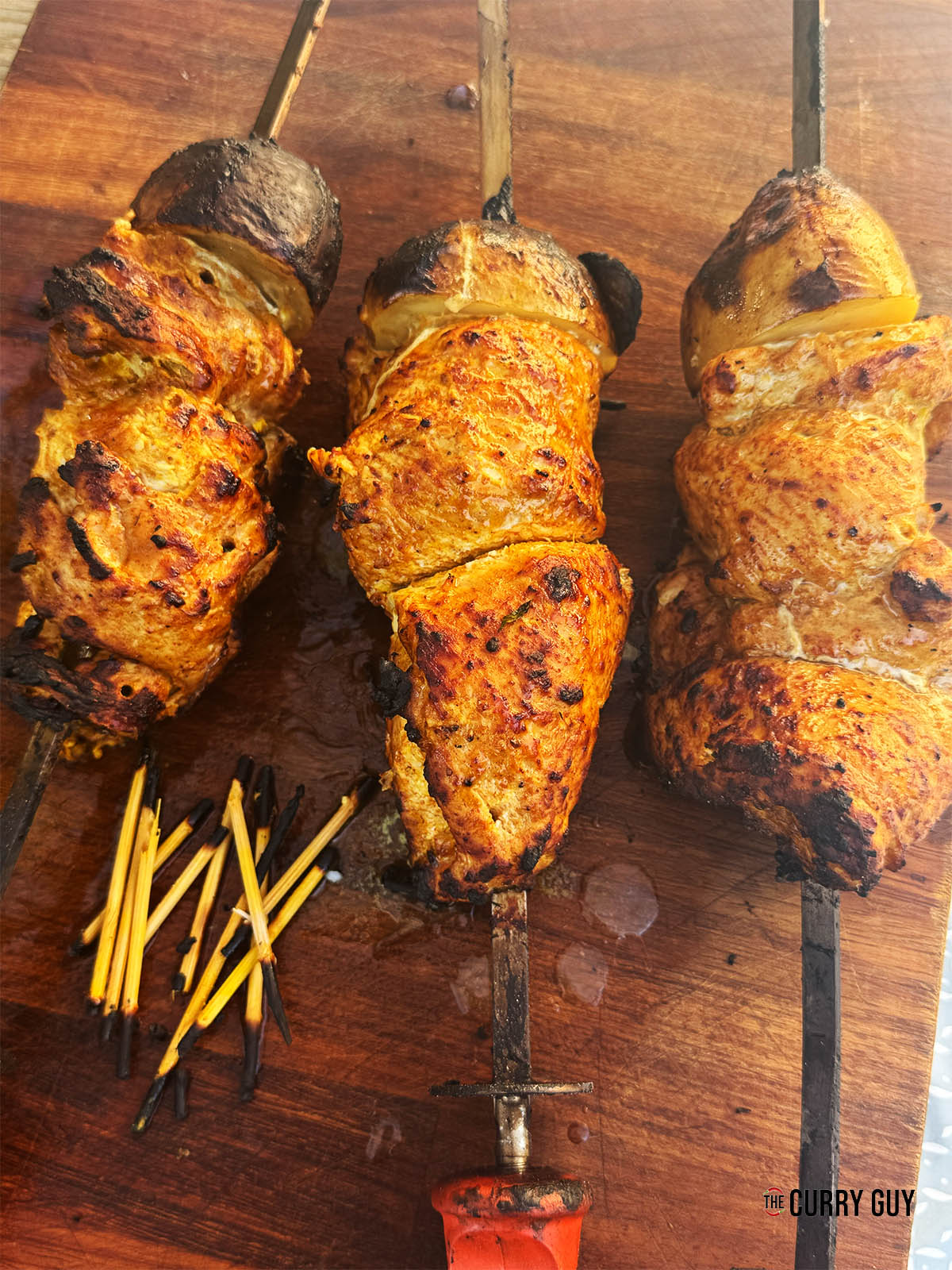 The cooked stuffed chicken roulades, resting on a cutting board.