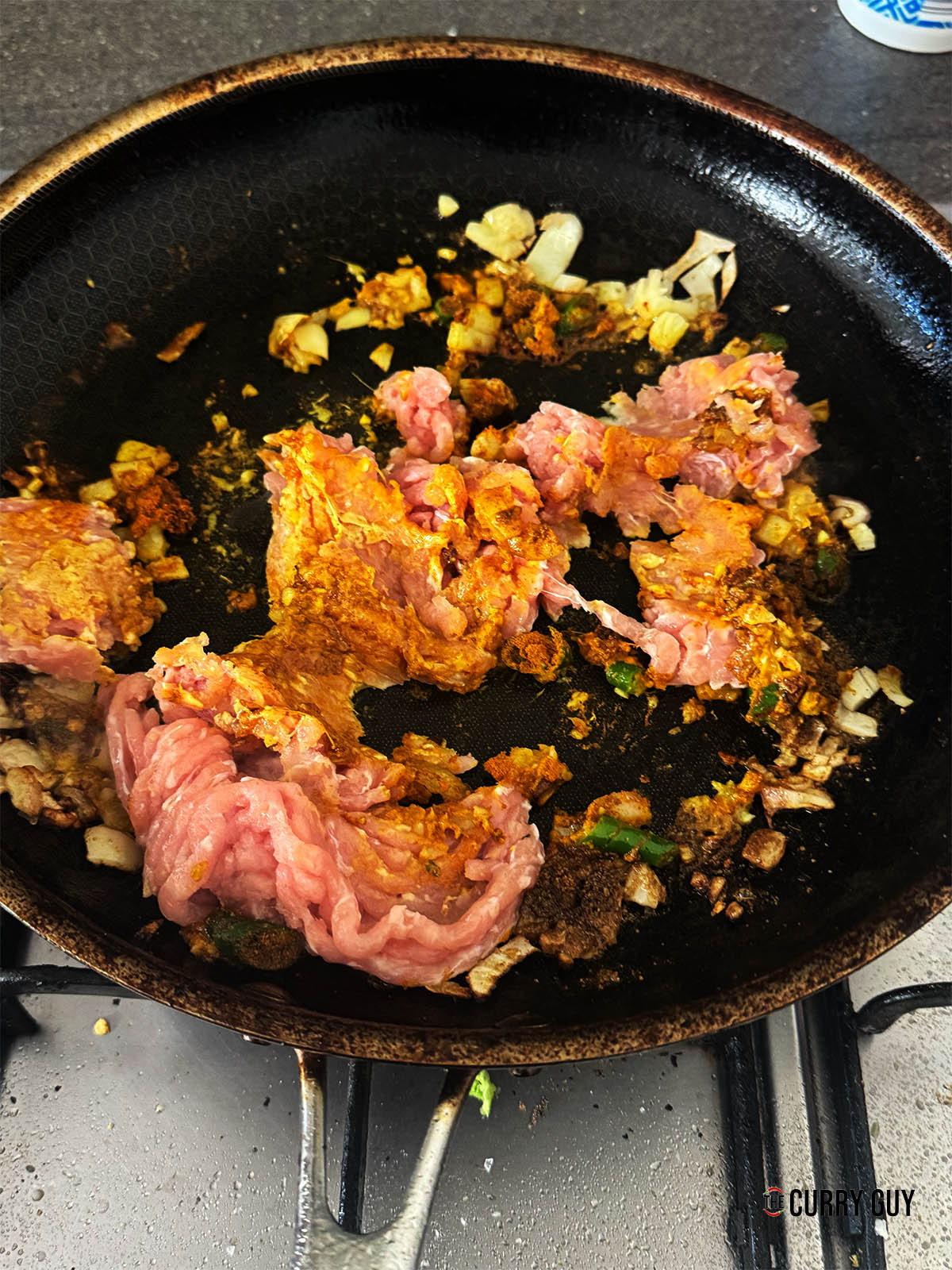 Stirring the chicken into this masala.