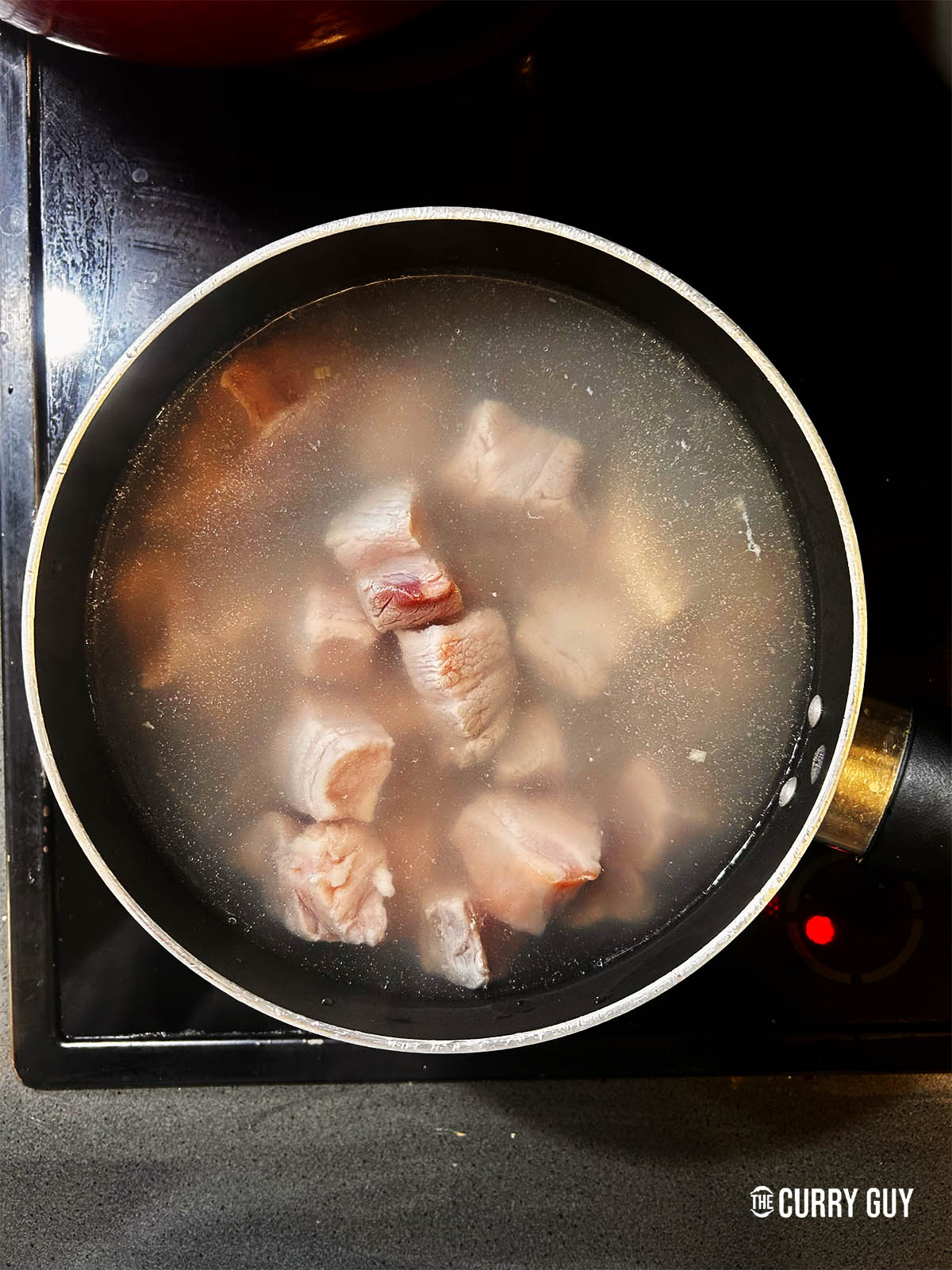 Boiling pork belly pieces in water for 5 minutes.
