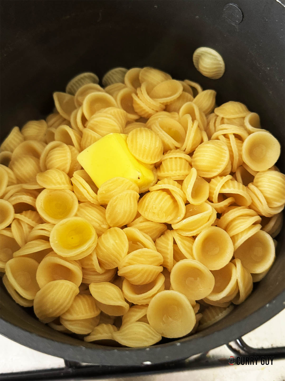The cooked pasta with butter melting into it.