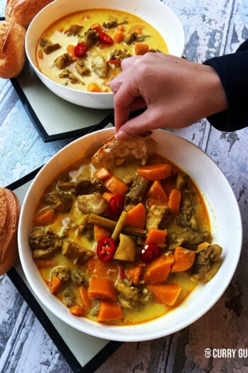 Vietnamese chicken curry in a serving bowl served with bread.