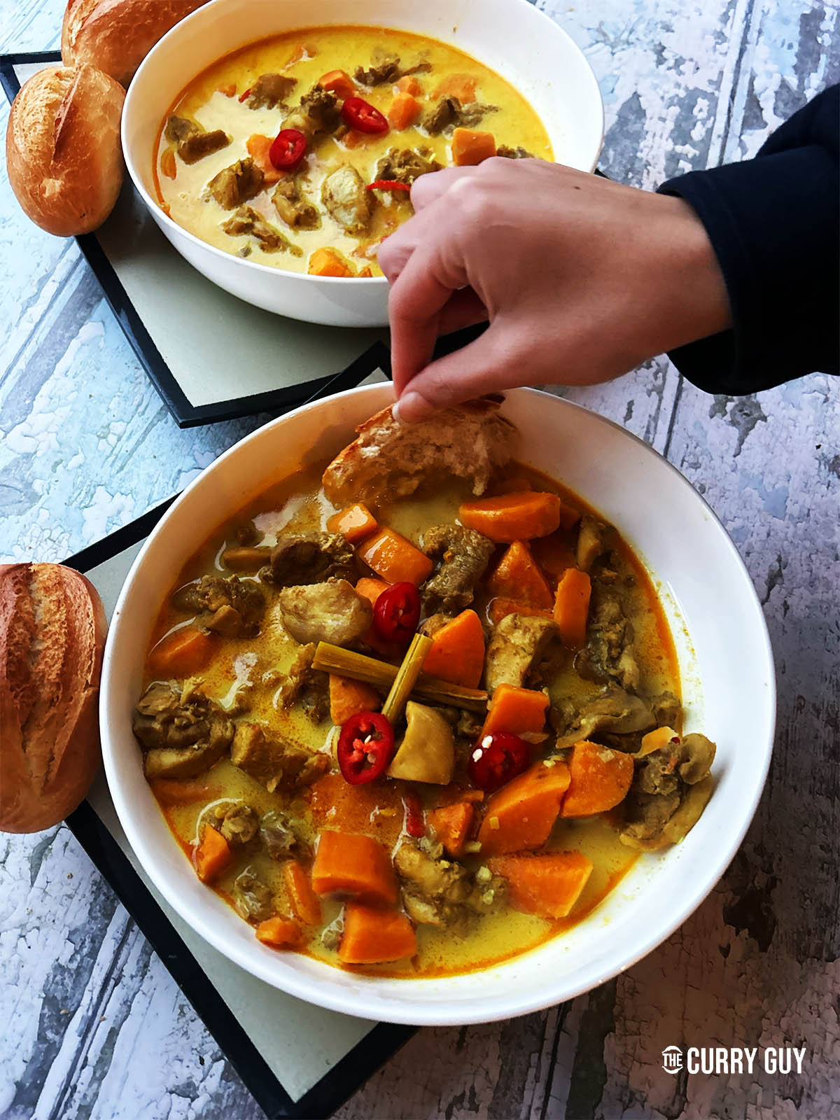 Vietnamese chicken curry in a serving bowl served with bread.