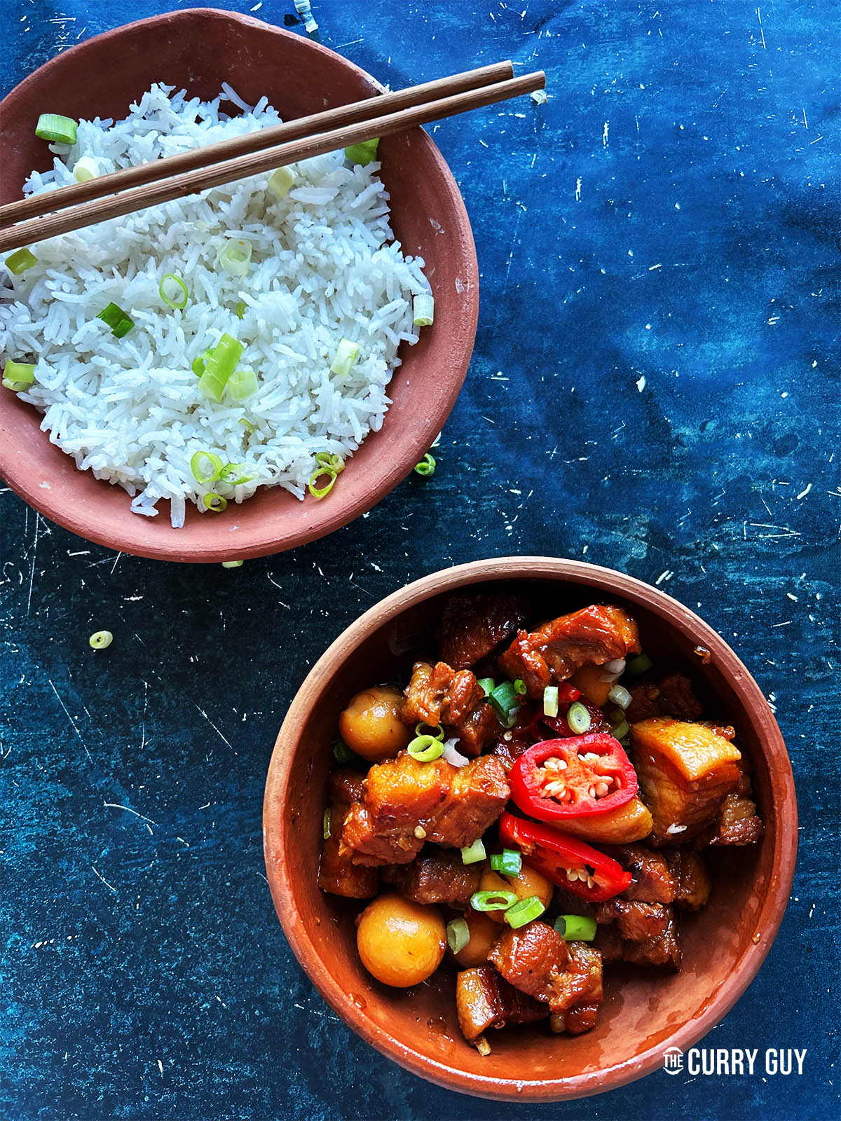 Thit Kho tao in a serving bowl next to a bowl of rice.