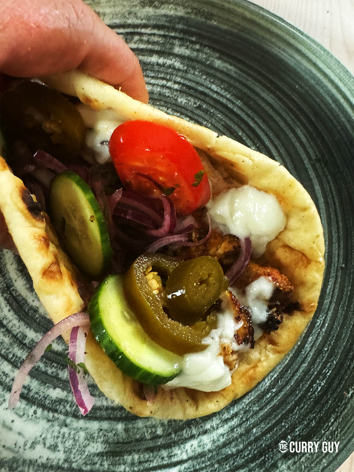 Chicken shawarma wrapped into flat bread with salad vegetables and garlic sauce.