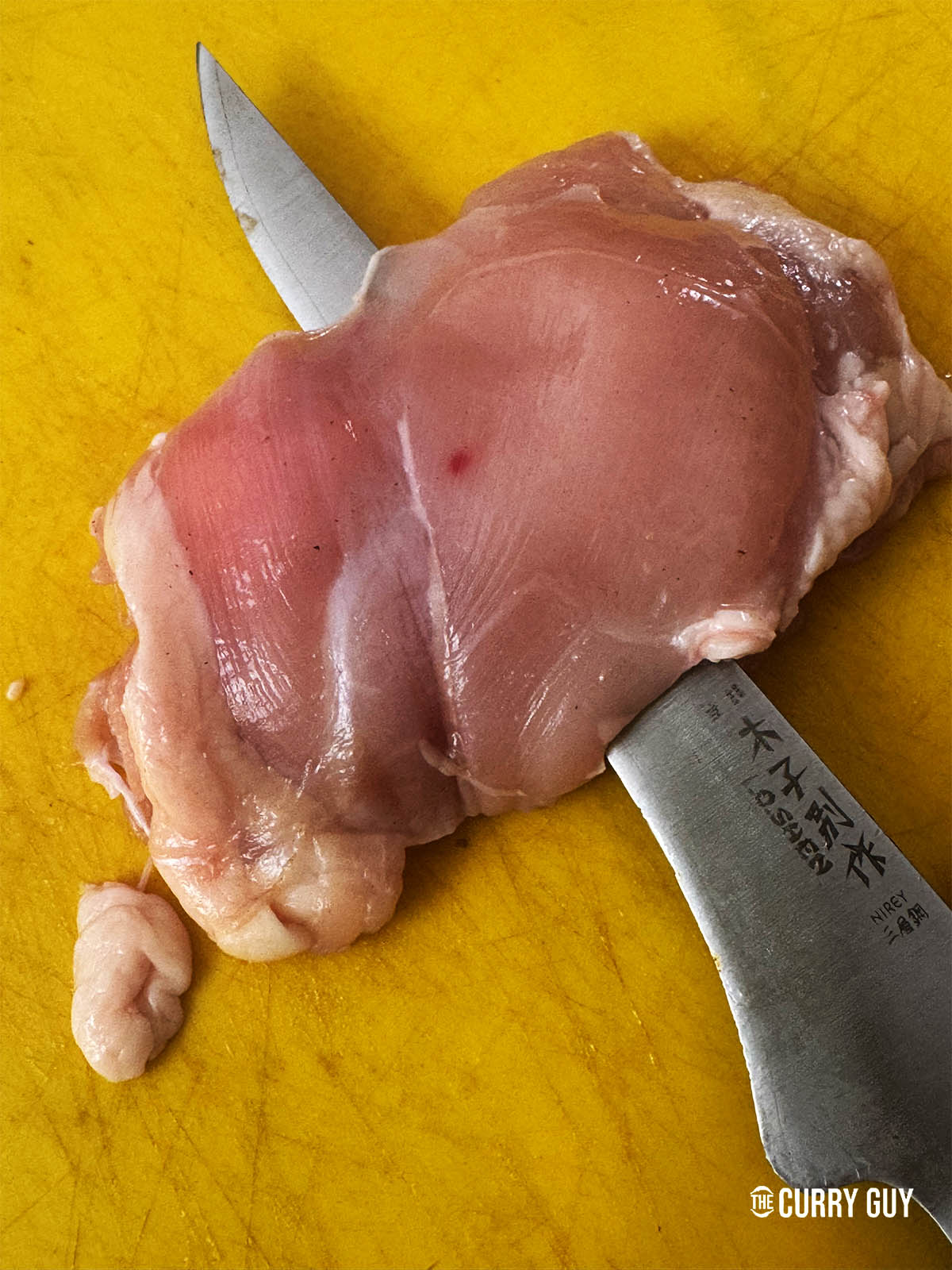 Slicking a chicken thigh lengthwise through the centre.
