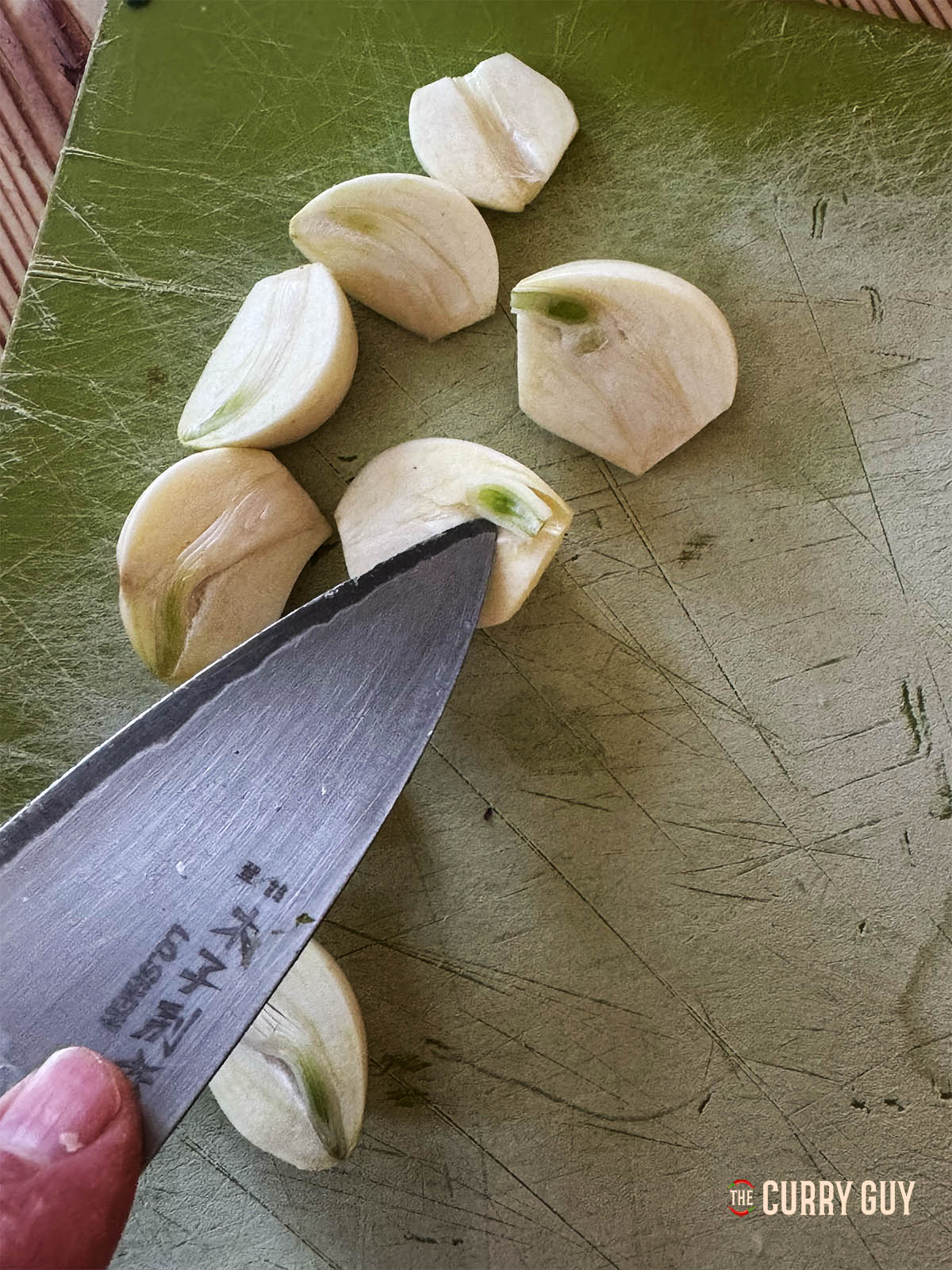Removing the green core in each piece of garlic.