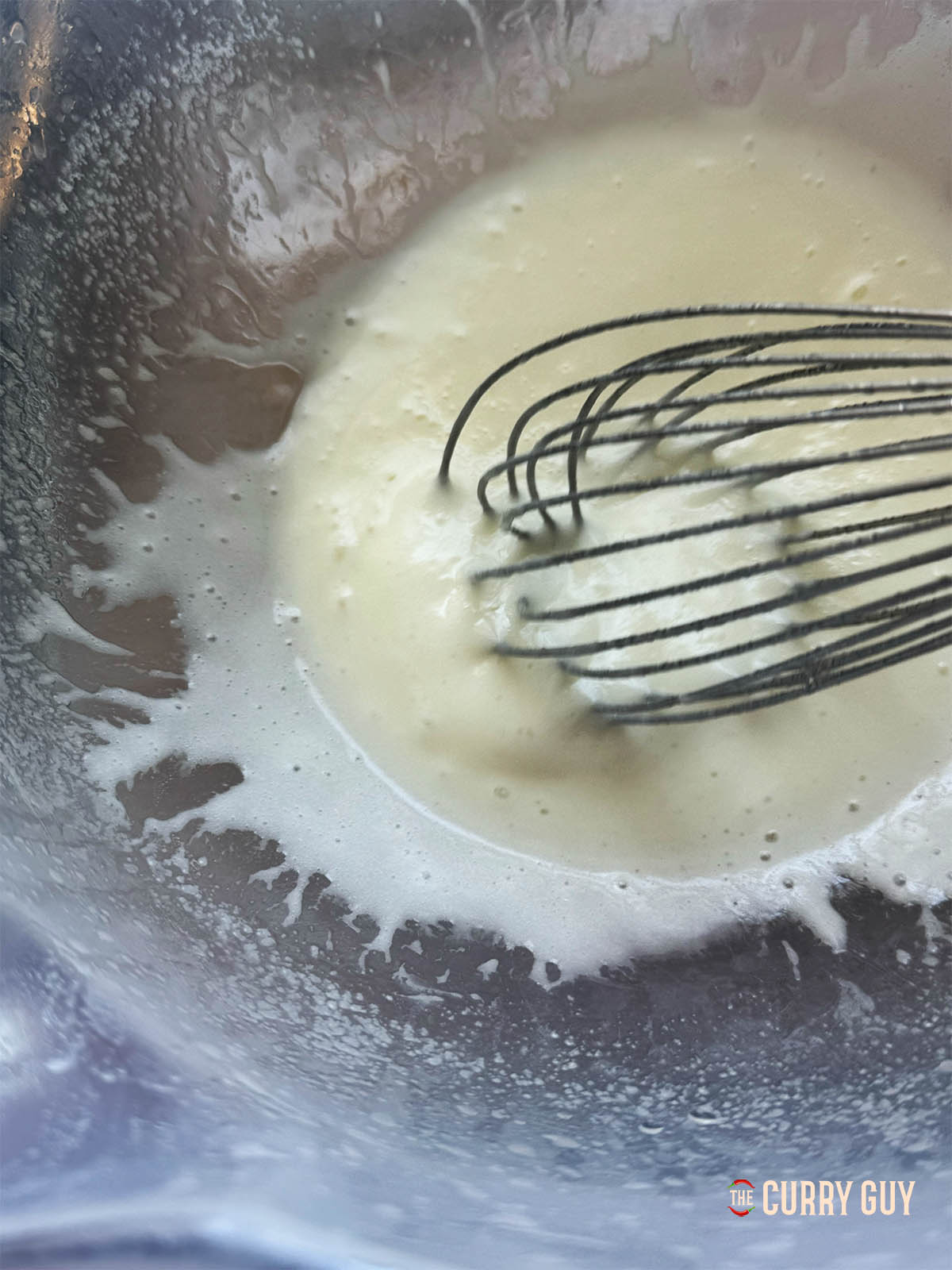 Whisking the egg white and the whisking in the blended garlic.