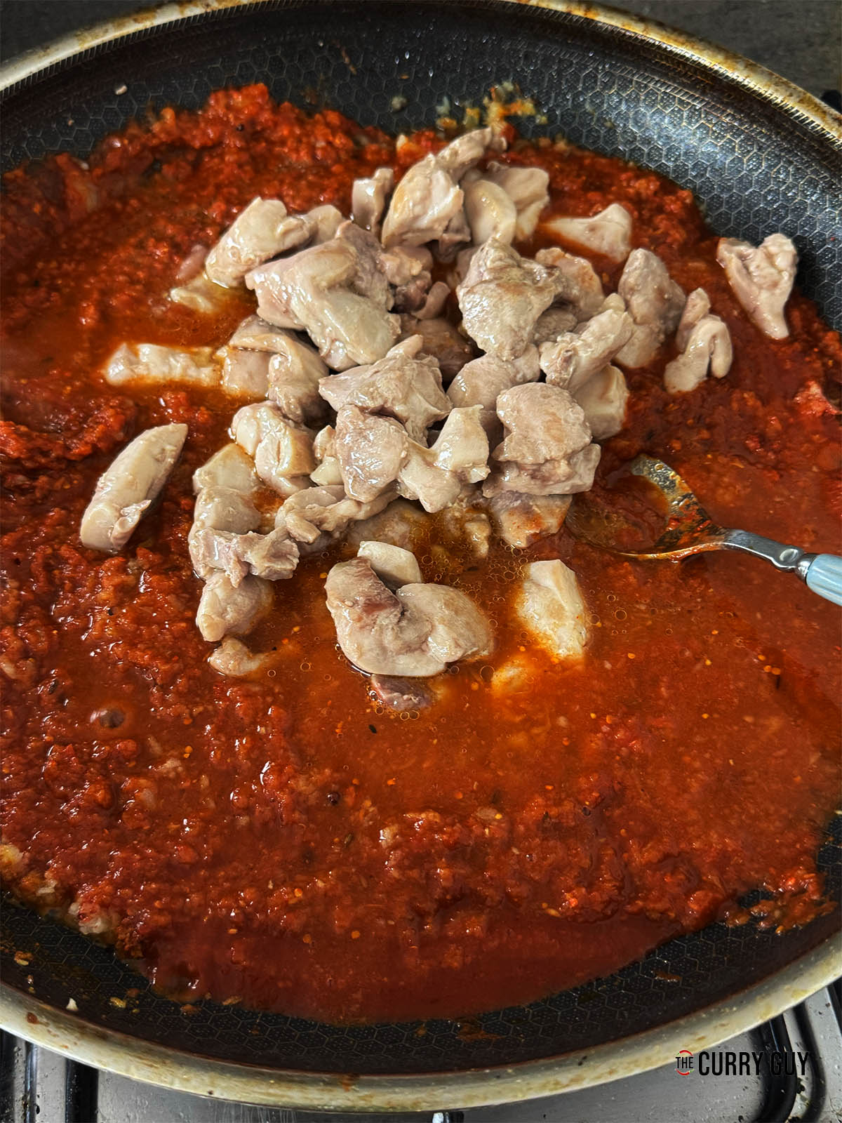 Returning the chicken to the pan and the stock.