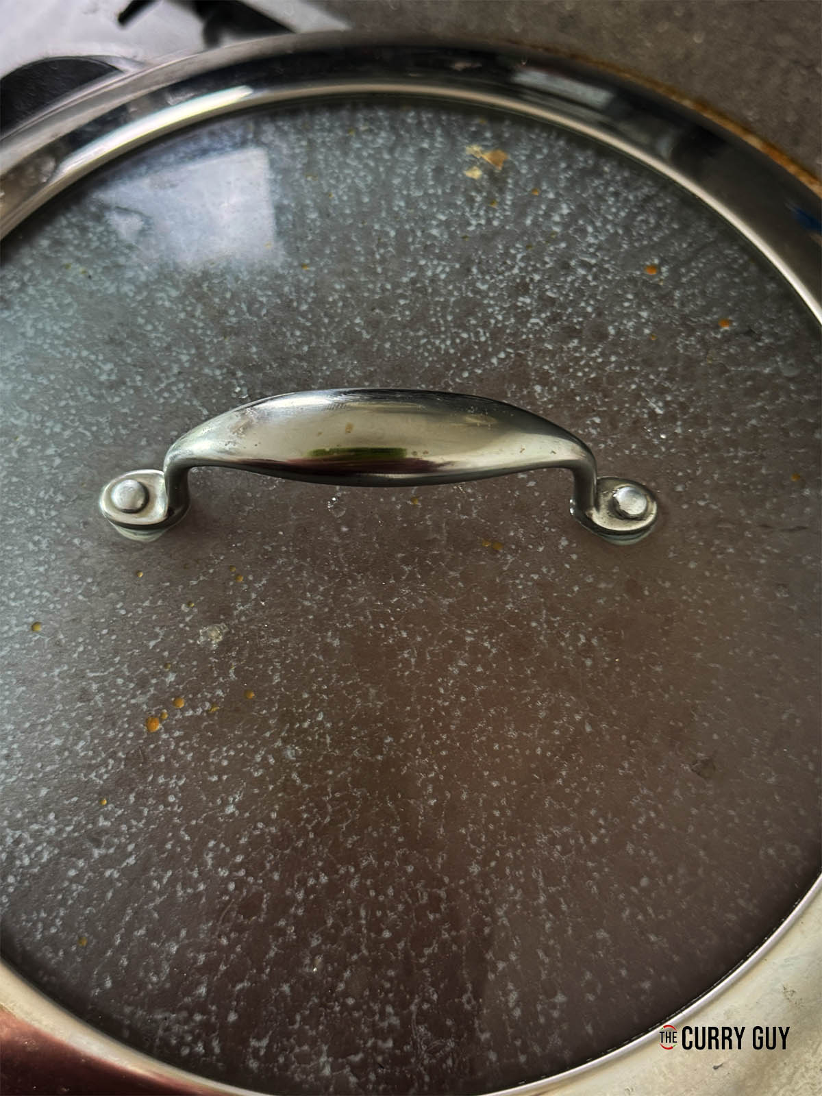 Covering the pan to let the sauce simmer.