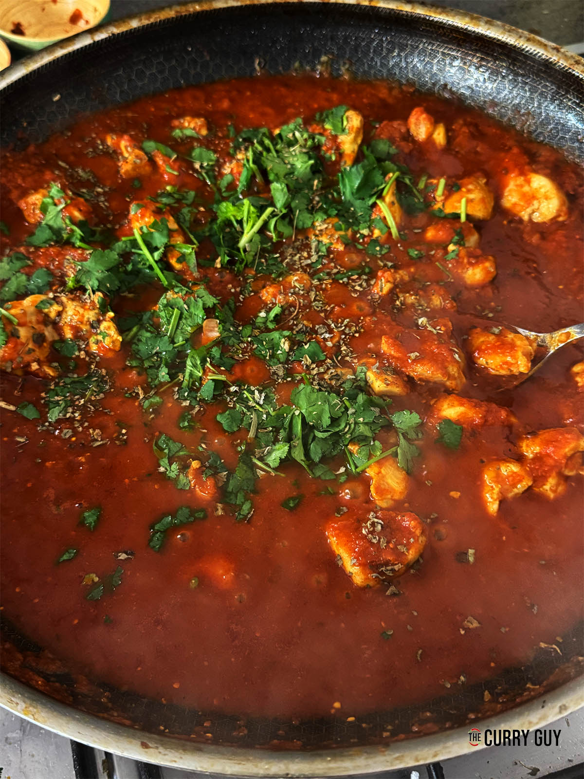 Removing the lid to let the curry cook down.