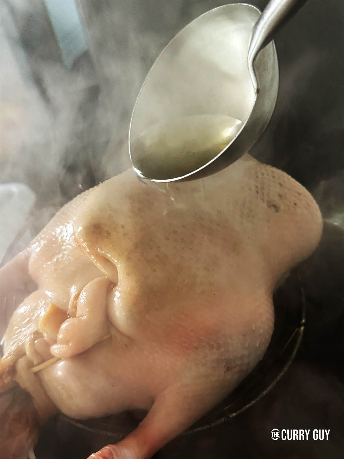 Pouring ladle fulls of the liquid over the duck.
