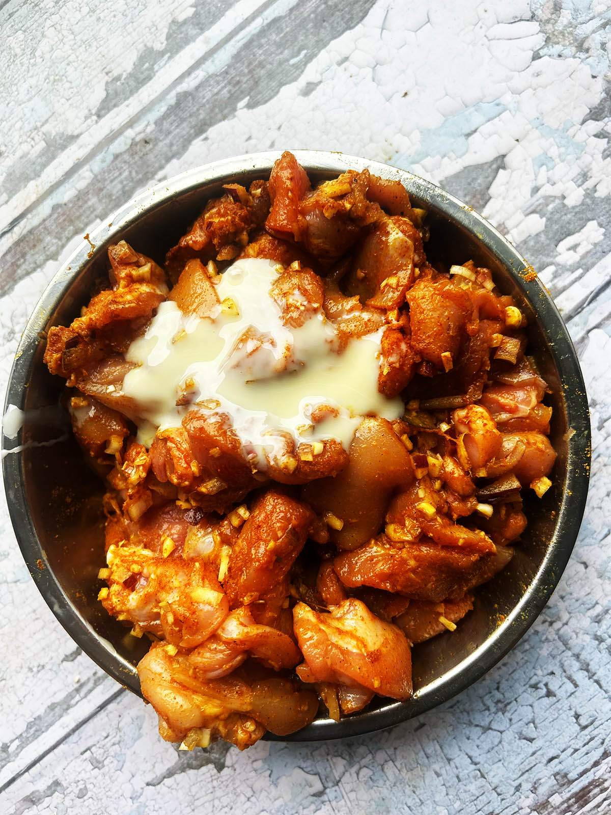 Mixing the marinade ingredients into the chicken.