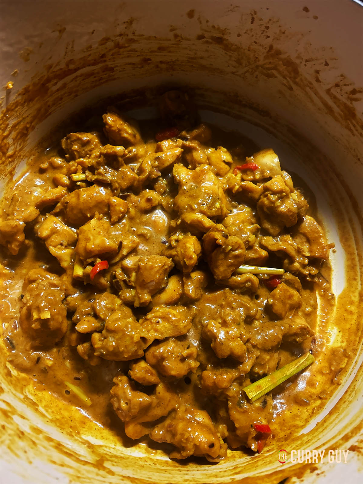 Adding a little water to the pan to help the chicken cook.
