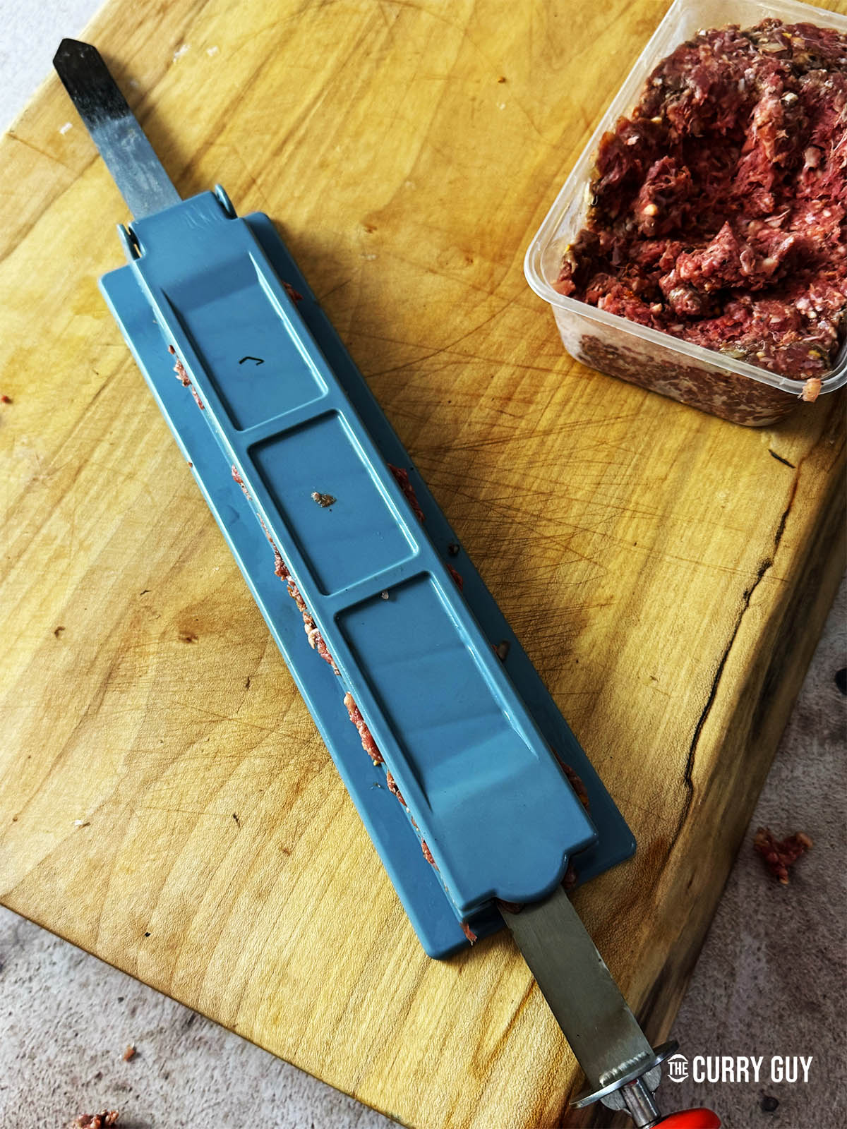 Pressing the meat on to the skewer with a kebab mould.