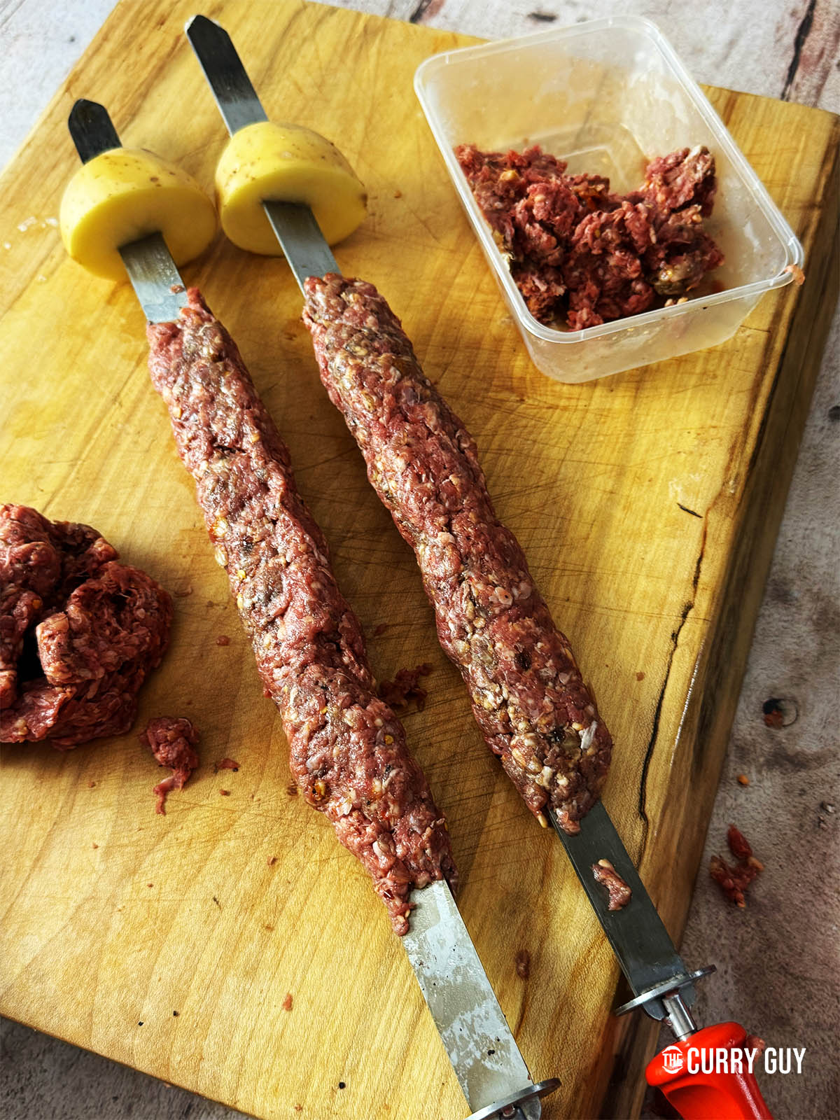 The meat skewers with potatoes at the end.