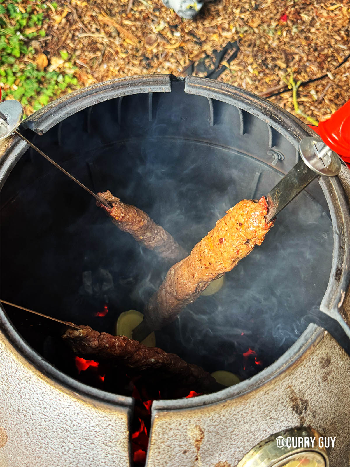 The kebabs cooking in a tandoor oven.