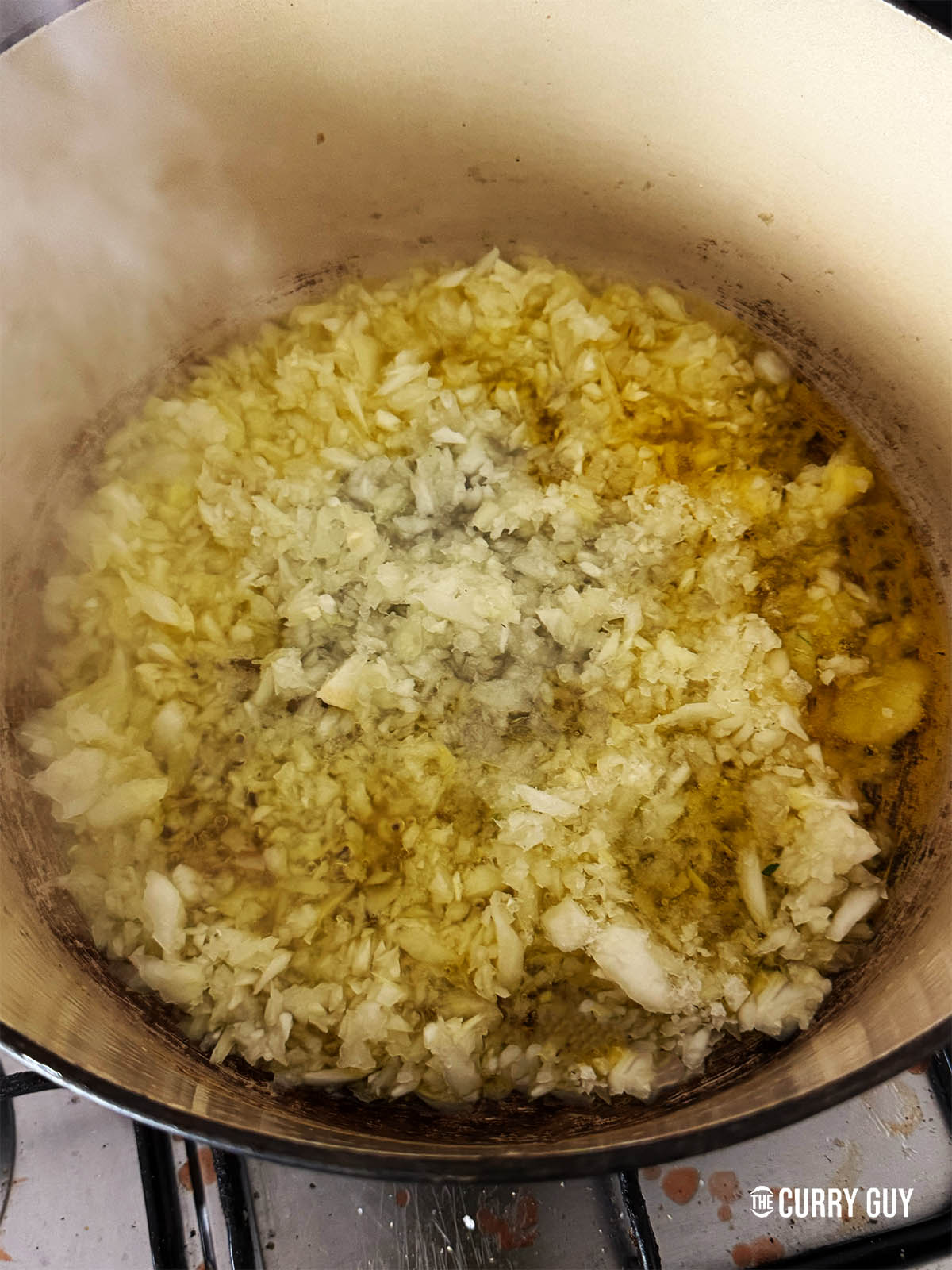 Frying the onions in ghee in a heavy pot.