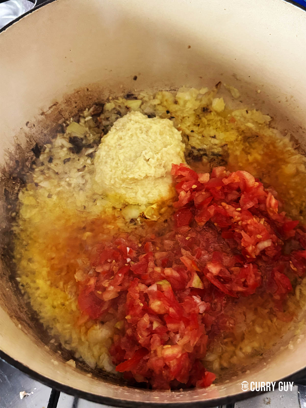 Stirring in the garlic and ginger paste and the chopped tomatoes.