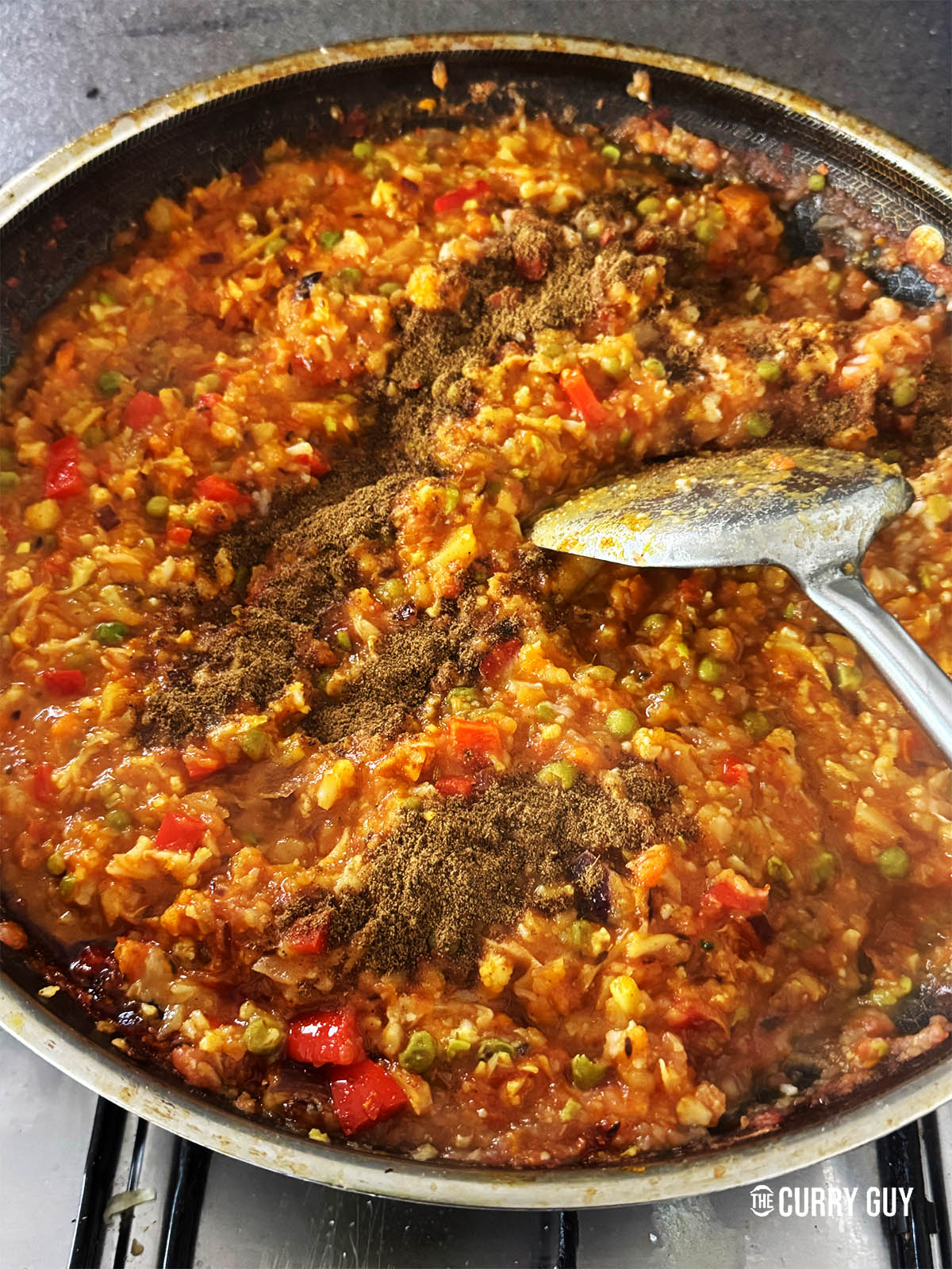 Sprinkling the pav bhaji with salt and garam masala