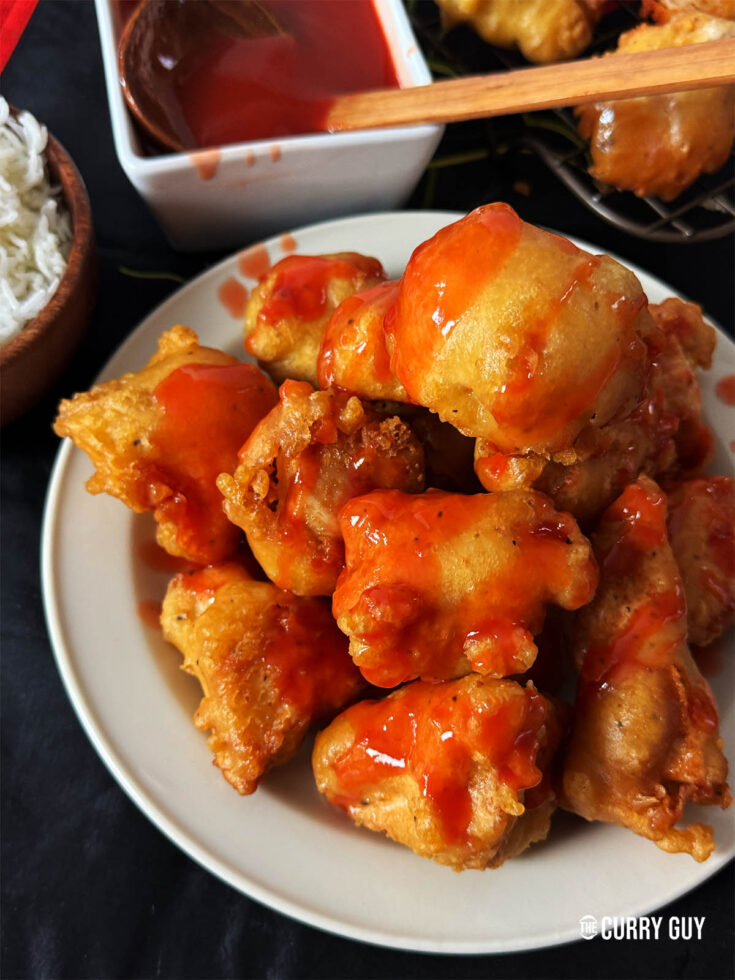 Sweet and sour chicken balls on a serving plate.