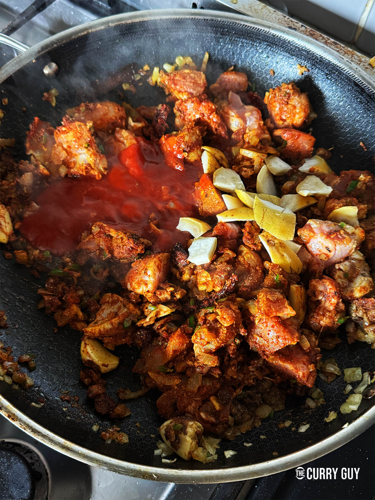 Adding the passata and shatkora rinds along with just enough water to cover. 