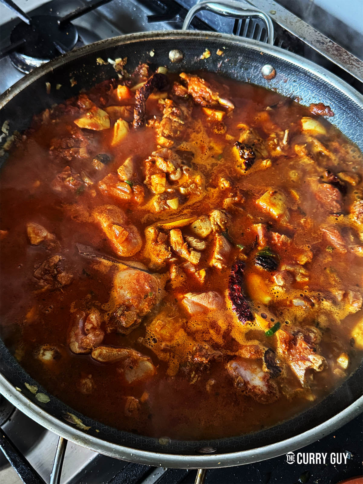 Simmering the curry to thicken the sauce.