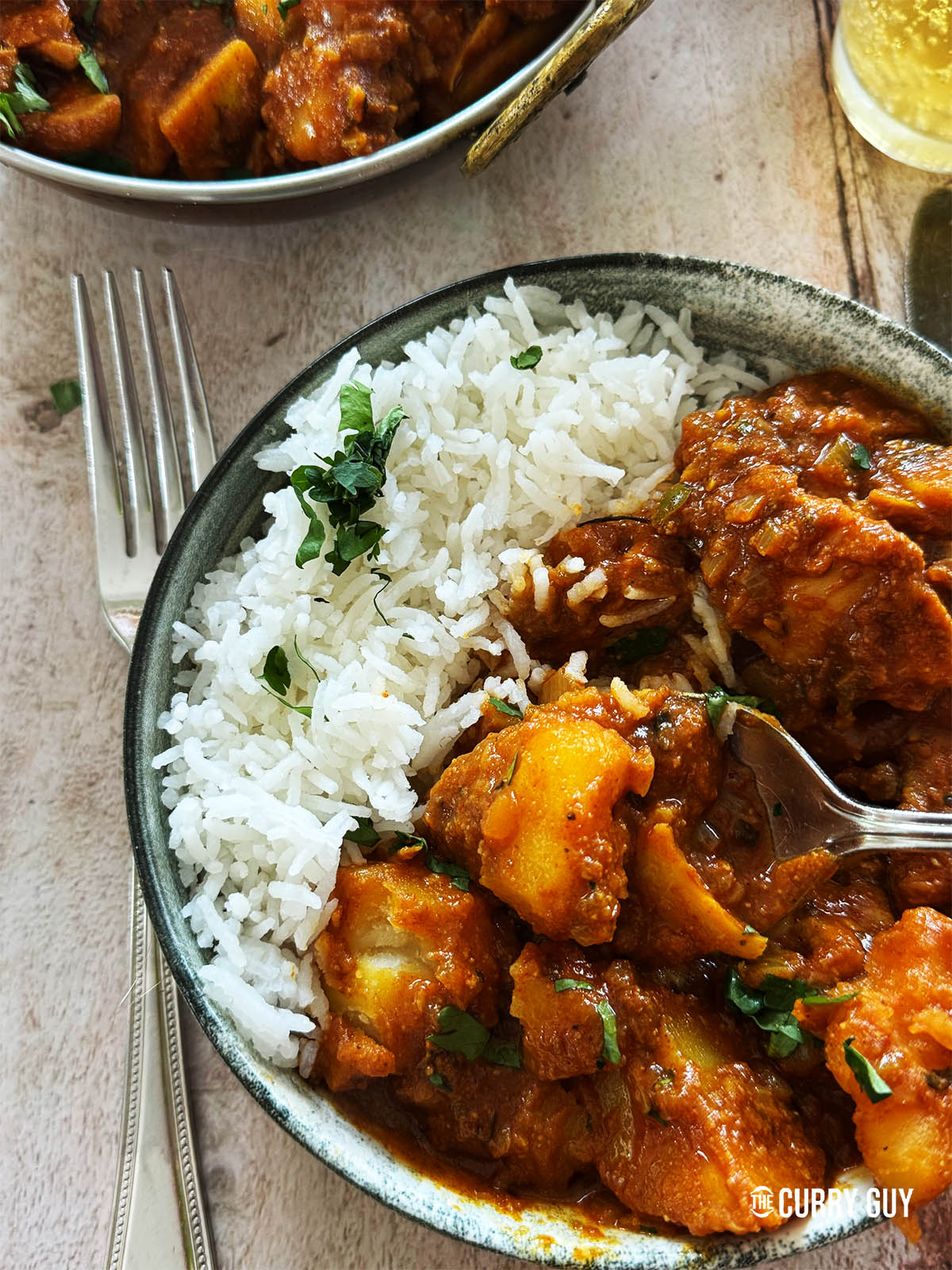 The Bengali chicken curry in a serving bowl with rice.