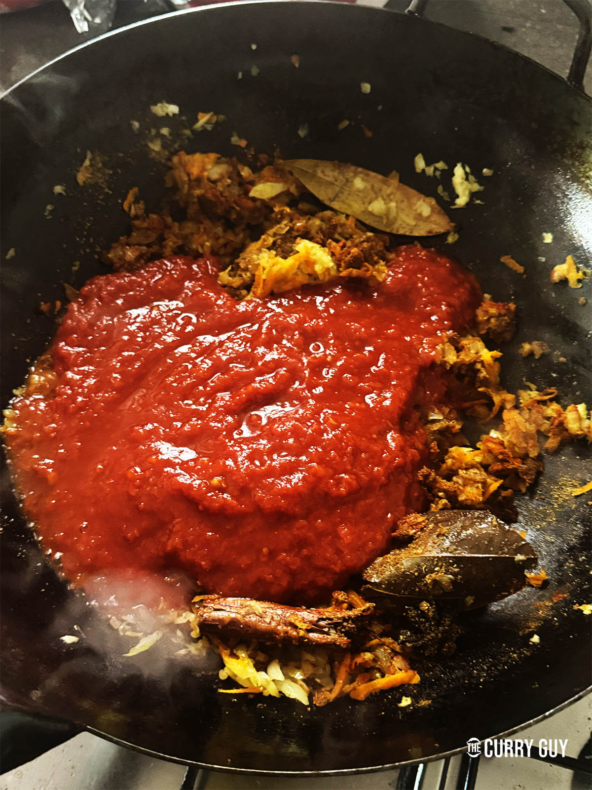 Adding the chopped tomatoes to the pan.