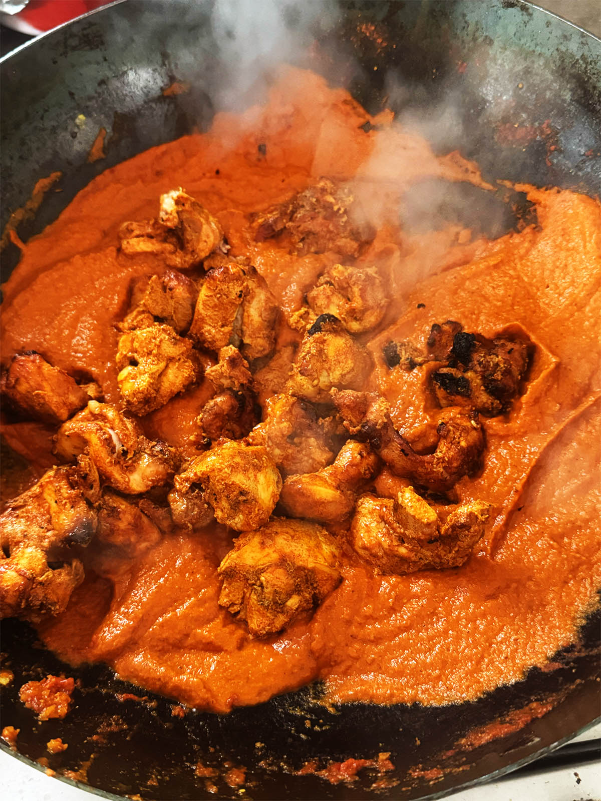 Adding the chicken to the sauce.