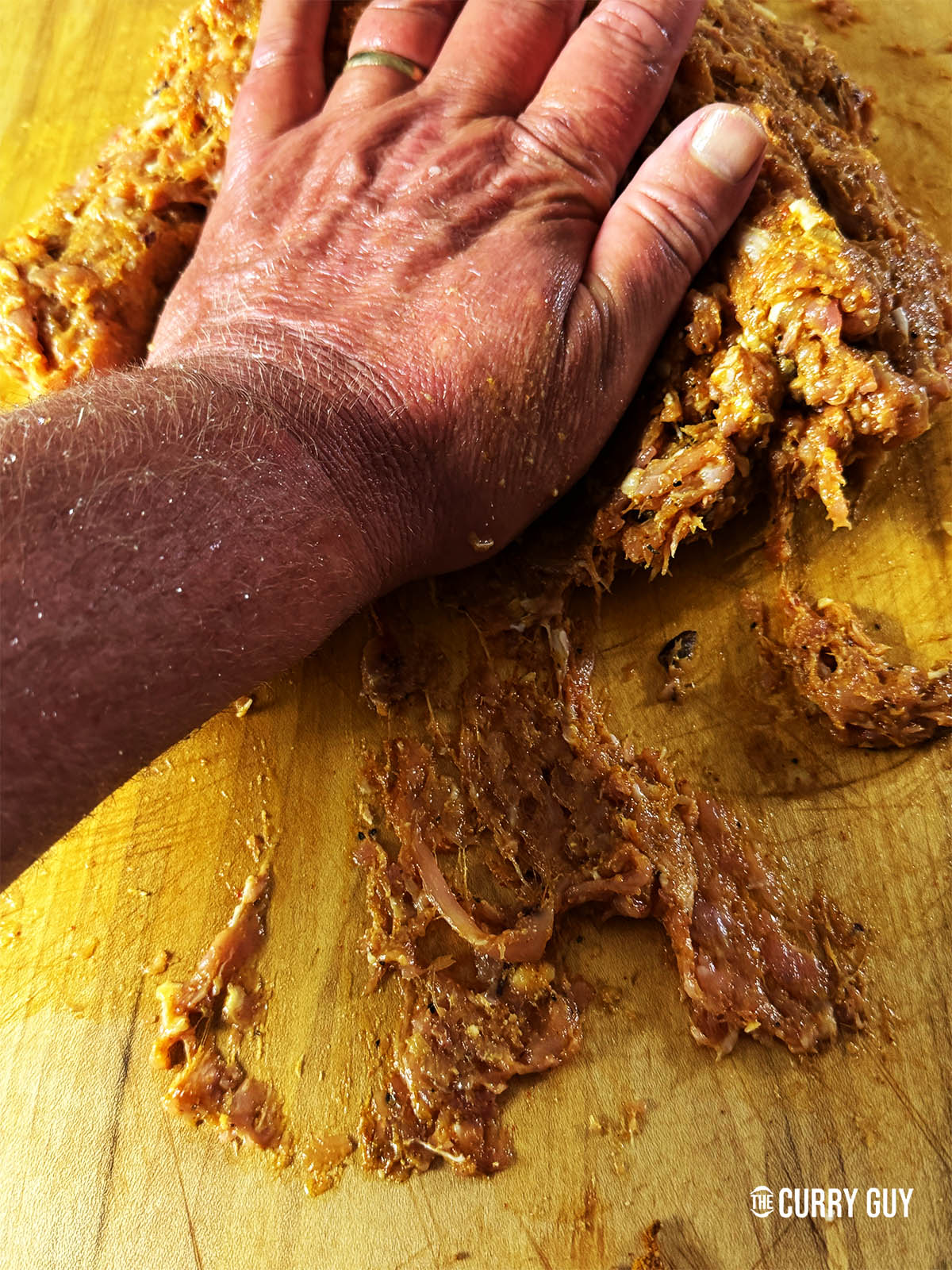 Kneading the meat mixture to break down the meat so that it is really smooth.